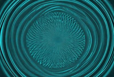 The primary subject of the image is a blue circle with a pattern of swirls or waves. The setting is a blue surface, which could be a wall or a table. The visual style appears to be a digital art or illustration, as the swirls are intricately designed and the overall atmosphere is vibrant and dynamic. The dominant colors are blue and white, creating a sense of depth and movement in the image.