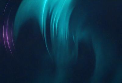 The primary subject of the image is a blue and green light, which appears to be a neon light or a light effect. The light is shining through a blue background, creating a visually striking scene. The visual style of the image is a combination of a photo and a digital art, as it captures the light's movement and the blue background. The colors and mood of the image are predominantly blue and green, with a sense of depth and movement.