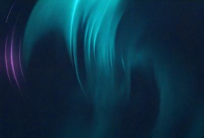 The primary subject of the image is a blue and green light, which appears to be a neon light or a light effect. The setting is a dark background, which contrasts with the light. The visual style of the image is a close-up of the light, showcasing its vibrant colors and unique texture. The colors and mood of the image are predominantly blue and green, creating a serene and calming atmosphere.