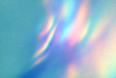 The primary subject of the image is a colorful, swirling pattern that resembles a rainbow. The setting is a blue background, which provides a contrasting color to the vibrant pattern. The visual style of the image is a combination of digital art and illustration, creating a unique and eye-catching design. The dominant colors in the image are blue, purple, and pink, which contribute to a lively and cheerful atmosphere.