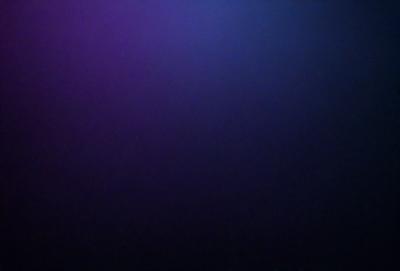 The primary subject of the image is a purple background. The setting is a dark, empty space with no visible objects or people. The visual style is a close-up of the purple background, which creates a moody and atmospheric mood.