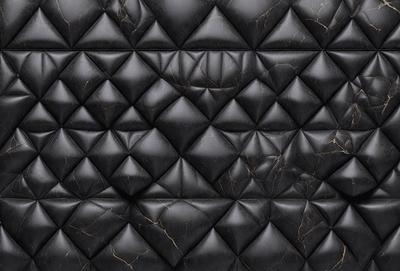 The primary subject of the image is a black leather material with a pattern of black diamonds. The setting is a black background, and the visual style appears to be a close-up of the leather material. The colors and mood of the image are predominantly dark and moody, with the black diamond pattern adding a touch of sophistication and elegance.