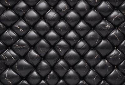 The primary subject of the image is a black leather couch with a black and white pattern. The setting is a room with a black and white patterned wallpaper. The visual style is a close-up of the couch, showcasing its unique design. The colors and mood of the image are predominantly black and white, giving it a modern and sophisticated appearance.