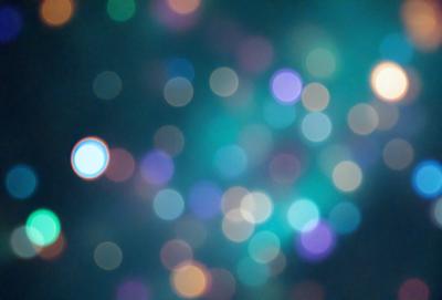 The primary subject of the image is a brightly colored, swirling pattern of lights. The setting is a dark background, which contrasts with the vibrant colors of the lights. The visual style appears to be a combination of a photo and digital art, creating a unique and eye-catching effect. The colors and mood of the image are lively and energetic, with the swirling lights evoking a sense of movement and dynamism.