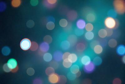 The primary subject of the image is a brightly colored, swirling pattern of lights. The setting is a dark background, which contrasts with the vibrant colors of the lights. The visual style appears to be a combination of a photo and digital art, creating a unique and eye-catching effect. The colors and mood of the image are lively and energetic, with the swirling lights evoking a sense of movement and dynamism.