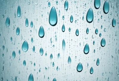 The primary subject of the image is a large, clear glass window with a blue tint. The window is filled with water droplets, creating a visually appealing and serene scene. The water droplets are scattered throughout the window, creating a sense of depth and dimension. The overall atmosphere of the image is calm and peaceful, with the blue tint of the window adding a touch of tranquility.