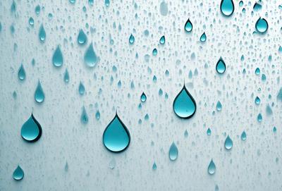 The primary subject of the image is a large number of blue droplets falling on a white surface. The setting is a white wall, and the visual style is a photo. The dominant colors are blue and white, creating a serene and calming atmosphere.