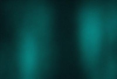 The primary subject of the image is a blue wall with a patterned texture. The setting is a dark room, and the visual style appears to be a photo. The dominant colors are blue and black, creating a moody atmosphere.