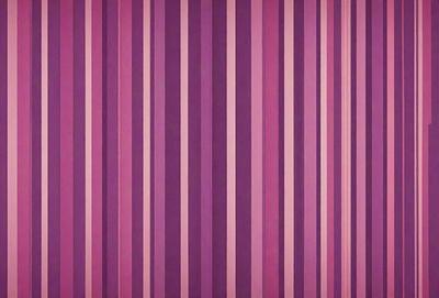 The primary subject of the image is a purple and white striped wallpaper. The setting is a room with a purple wall, and the visual style is a patterned wallpaper. The dominant colors are purple and white, creating a calm and soothing atmosphere.