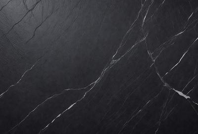 The primary subject of the image is a black marble countertop. The setting is a dark room, and the visual style is a close-up of the marble countertop. The countertop appears to be a dark grey color, giving it a sophisticated and elegant appearance.