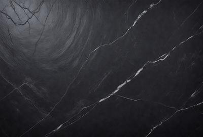 The primary subject of the image is a black marble countertop. The setting is a kitchen, with the countertop being the main focus of the scene. The visual style is a close-up of the marble countertop, showcasing its texture and details. The colors and mood of the image are predominantly dark, with the black marble countertop being the main source of contrast and visual interest.
