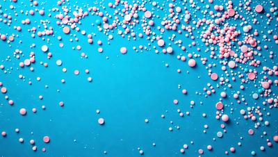 The primary subject of the image is a blue background with a pattern of pink and blue balls scattered across it. The setting appears to be a blue surface, possibly a wall or a table, with the balls creating a visually appealing and colorful pattern. The visual style of the image is a combination of photo and digital art, as the balls are arranged in a way that resembles a painting or a digital design. The colors and mood of the image are predominantly blue and pink, creating a sense of calmness