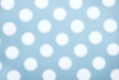 The primary subject of the image is a pattern of white polka dots on a blue background. The setting is a wall, and the visual style is a patterned design. The dominant colors are white and blue, creating a clean and fresh atmosphere.