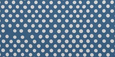 The primary subject of the image is a blue background with white polka dots. The setting is a patterned surface, and the visual style is a combination of a photo and digital art. The dominant colors are blue and white, creating a calm and soothing atmosphere.