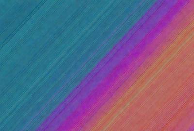 The primary subject of the image is a colorful striped pattern, which appears to be a digital art or illustration. The setting is a blue background, and the visual style is a combination of colors and patterns. The dominant colors are purple, pink, and blue, creating a vibrant and lively atmosphere.