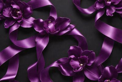 The primary subject of the image is a close-up of a purple flower with a gold center. The setting is a black background, which provides a contrasting and dramatic effect. The visual style is a combination of a photo and digital art, as the flower appears to be a digital illustration. The dominant colors are purple and gold, creating a sense of elegance and sophistication.