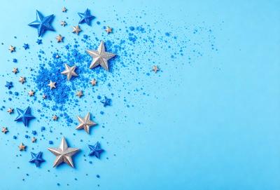 The primary subject of the image is a blue background with a pattern of stars. The setting is a blue surface, and the visual style appears to be a digital art or illustration. The dominant colors are blue and white, creating a calm and serene atmosphere.