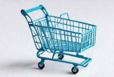 The primary subject of the image is a blue plastic shopping cart. The cart is placed on a white surface, which serves as the background. The visual style of the image is a photo, capturing the cart in its entirety. The dominant colors in the image are blue and white, creating a clean and modern atmosphere.