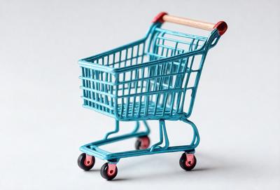 The primary subject of the image is a blue plastic shopping cart. The cart is placed on a white surface, which serves as the background. The visual style of the image is a combination of photo and digital art, as it appears to be a realistic representation of a shopping cart. The dominant colors in the image are blue and white, creating a clean and modern atmosphere.