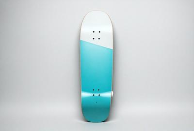 The primary subject of the image is a blue and white skateboard. The skateboard is standing upright on a white surface, which serves as the background. The visual style of the image is a photo, capturing the skateboard in its natural environment. The colors and mood of the image are predominantly white and blue, creating a clean and calm atmosphere.