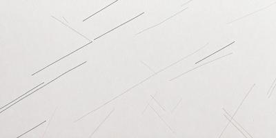 The primary subject of the image is a white surface with a pattern of black lines. The setting appears to be a white wall, and the visual style is a close-up of the pattern. The dominant colors are white and black, creating a clean and minimalist atmosphere.