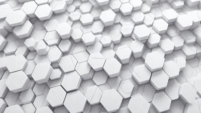 The primary subject of the image is a white wall with a pattern of white hexagons. The setting is a white room, and the visual style is a close-up of the wall. The dominant colors are white, and the overall atmosphere is clean and minimalistic.