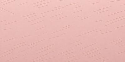 The primary subject of the image is a close-up of a pink surface with a pattern of white lines. The setting appears to be a room with a pink wall. The visual style is a close-up of the pink wall, which gives a sense of texture and pattern. The colors and mood of the image are predominantly pink and white, creating a calm and soothing atmosphere.