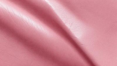 The primary subject of the image is a pink leather material. The setting is a close-up view of the leather, showcasing its texture and color. The visual style is a realistic representation of the leather material. The dominant colors are pink and red, creating a warm and inviting atmosphere.