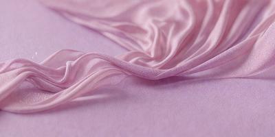 The primary subject of the image is a piece of pink fabric, which is the main object, scene, or focus of the image. The setting or background of the image is a pink surface, which adds to the overall atmosphere of the image. The visual style of the image is a close-up of the pink fabric, showcasing its texture and details. The colors and mood of the image are predominantly pink, creating a warm and inviting atmosphere.
