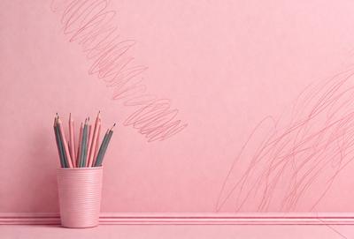 The primary subject of the image is a pink wall with a pen and pencils placed on it. The setting is a room with a pink wall, and the visual style appears to be a combination of a photo and a drawing. The colors and mood of the image are predominantly pink, creating a warm and inviting atmosphere.