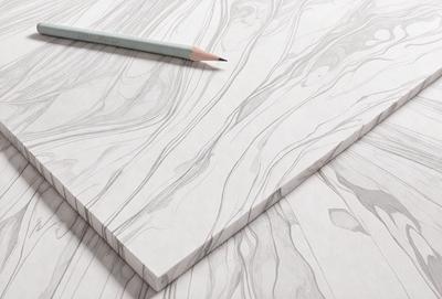 The primary subject of the image is a pencil and a piece of paper. The setting is a table, and the visual style is a drawing or illustration. The colors and mood of the image are predominantly white, giving it a clean and minimalist appearance.