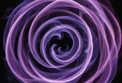 The primary subject of the image is a purple spiral, which appears to be a smoke or a vapor trail. The setting is a dark background, which contrasts with the purple spiral. The visual style is a close-up of the spiral, emphasizing its intricate pattern. The colors and mood of the image are predominantly purple, creating a sense of mystery and elegance.