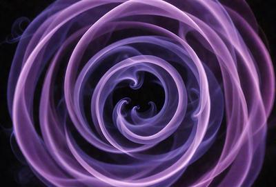 The primary subject of the image is a purple spiral, which appears to be a smoke or a vapor trail. The setting is a dark background, which contrasts with the purple spiral. The visual style is a close-up of the spiral, emphasizing its intricate pattern. The colors and mood of the image are predominantly purple, creating a sense of mystery and elegance.
