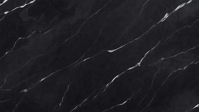 The primary subject of the image is a black marble countertop. The setting is a kitchen, with the countertop being the main focus of the scene. The visual style is a close-up of the marble countertop, showcasing its texture and pattern. The colors and mood of the image are predominantly dark, with the black marble countertop being the main source of contrast.