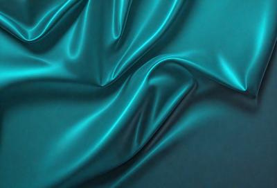 The primary subject of the image is a close-up of a blue fabric, possibly a piece of silk or velvet. The setting is a dark background, which contrasts with the vibrant blue fabric. The visual style appears to be a photo, as the fabric is captured in detail. The colors and mood of the image are predominantly blue, creating a calm and serene atmosphere.