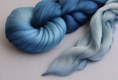 The primary subject of the image is a blue and white yarn, which is the main focus of the scene. The yarn is displayed on a white surface, creating a clean and minimalist visual style. The colors of the yarn are predominantly blue and white, giving the image a calm and soothing atmosphere.