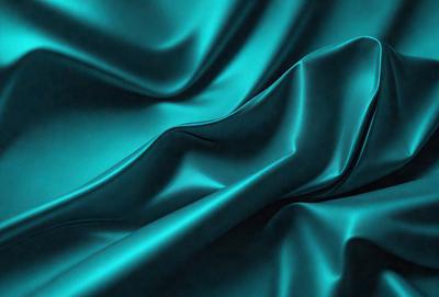 The primary subject of the image is a blue fabric, which appears to be a piece of silk. The setting is a dark background, which contrasts with the vibrant blue color of the fabric. The visual style is a close-up of the fabric, showcasing its texture and details. The colors and mood of the image are predominantly blue, creating a calm and serene atmosphere.