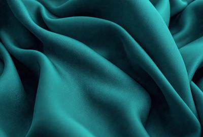 The primary subject of the image is a blue fabric, which appears to be a piece of cloth or a curtain. The setting is a room with a blue background, which complements the blue fabric. The visual style is a close-up of the blue fabric, showcasing its texture and color. The colors and mood of the image are predominantly blue, creating a calm and serene atmosphere.