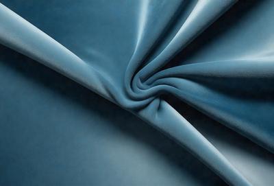 The primary subject of the image is a blue fabric, possibly a piece of cloth or a curtain. The setting is a dark background, which contrasts with the blue fabric. The visual style appears to be a close-up of the fabric, showcasing its texture and color. The colors and mood of the image are predominantly blue, creating a calm and serene atmosphere.