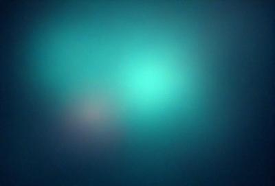 The primary subject of the image is a green, glowing light. The setting is a dark, blue background, which contrasts with the bright green light. The visual style appears to be a digital art or illustration, as the light seems to be a part of a larger design or pattern. The colors and mood of the image are predominantly dark and moody, with the green light providing a contrasting and luminous element.