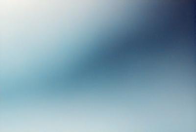 The primary subject of the image is a blue sky with a few clouds. The setting is a clear day with a cloudy sky. The visual style is a photo of the sky. The colors and mood are predominantly blue, creating a calm and serene atmosphere.