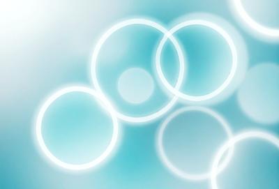 The primary subject of the image is a group of circles, which are the main objects in the scene. The circles are arranged in a visually appealing manner, creating a sense of depth and dimension. The setting is a blue background, which adds to the overall atmosphere of the image. The visual style of the image is a combination of photo and digital art, giving it a unique and artistic appearance. The dominant colors in the image are blue and white, which contribute to the overall mood of the scene.