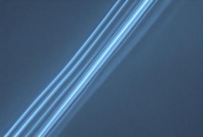 The primary subject of the image is a blue background with a long, thin, and bright blue line running through it. The line appears to be a light source, creating a striking visual effect. The setting is a dark background, which contrasts with the bright blue line. The visual style is a combination of a photo and a digital art, as the line appears to be digitally manipulated. The colors and mood of the image are predominantly blue, creating a calm and serene atmosphere.