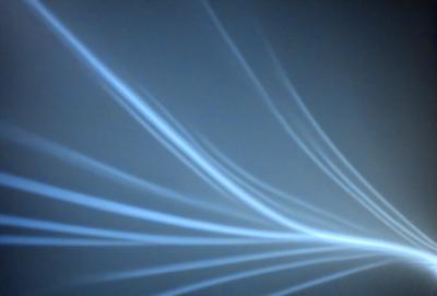 The primary subject of the image is a blue light, which appears to be a light source or a reflection of light. The setting is a dark background, which contrasts with the blue light. The visual style of the image is a combination of a photo and a digital art, as it captures the blue light in a unique and artistic manner. The colors and mood of the image are predominantly dark and moody, with the blue light providing a sense of depth and contrast.