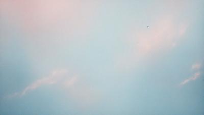 The primary subject of the image is a blue sky with a few clouds. The setting is a cloudy day, and the visual style is a photo. The colors and mood of the image are predominantly blue, creating a calm and serene atmosphere.