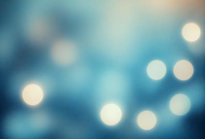 The primary subject of the image is a blue background with a pattern of white lights. The setting appears to be a dark room, and the visual style is a combination of a photo and digital art. The dominant colors are blue and white, creating a calm and serene atmosphere.