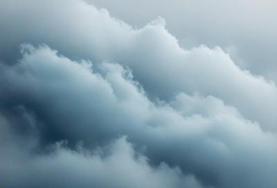 The primary subject of the image is a cloudy sky with a blue hue. The setting is a cloudy day, and the visual style is a natural, outdoor scene. The colors and mood of the image are predominantly blue, creating a calm and serene atmosphere.