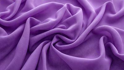 The primary subject of the image is a purple fabric, which is the main object, scene, or focus of the image. The setting or background of the image is a purple sheet, and the visual style appears to be a photo. The dominant colors in the image are purple, and the overall atmosphere is smooth and elegant.