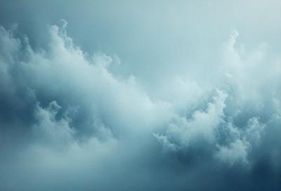 The primary subject of the image is a cloudy sky. The setting is a blue sky with clouds, creating a dramatic and moody atmosphere. The visual style is a photo, capturing the beauty of the cloudy sky. The colors and mood are predominantly blue, with the clouds adding depth and contrast to the scene.
