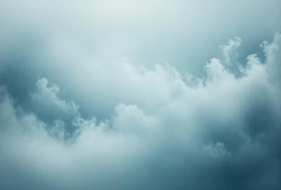 The primary subject of the image is a cloudy sky. The setting is a blue sky with clouds, creating a serene and peaceful atmosphere. The visual style is a natural, outdoor scene. The colors and mood are predominantly blue, with some white clouds, giving the impression of a calm and peaceful day.
